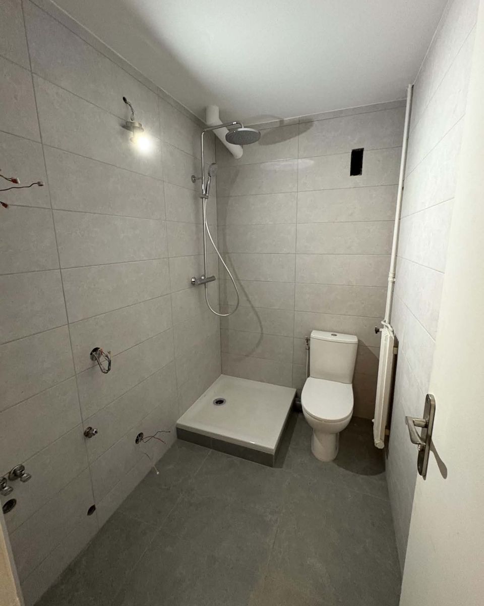 La même salle d’eau après travaux : faïence, receveur de douche et WC posés