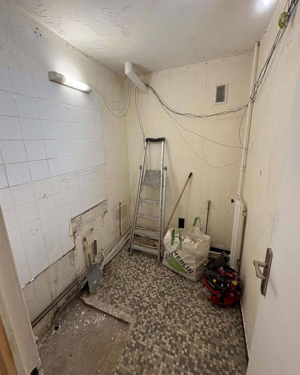 Salle d’eau avant travaux : carrelage déposé, réseaux à nu