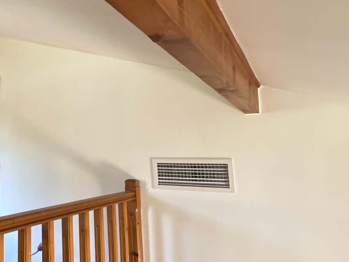 Grille de soufflage du gainable intégrée au mur d’une mezzanine, sous la poutre