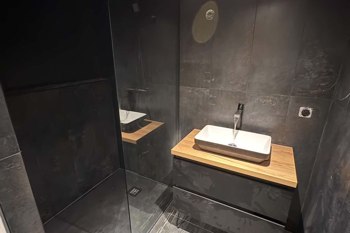 Salle d’eau anthracite : vasque à poser sur plan bois et douche à l’italienne